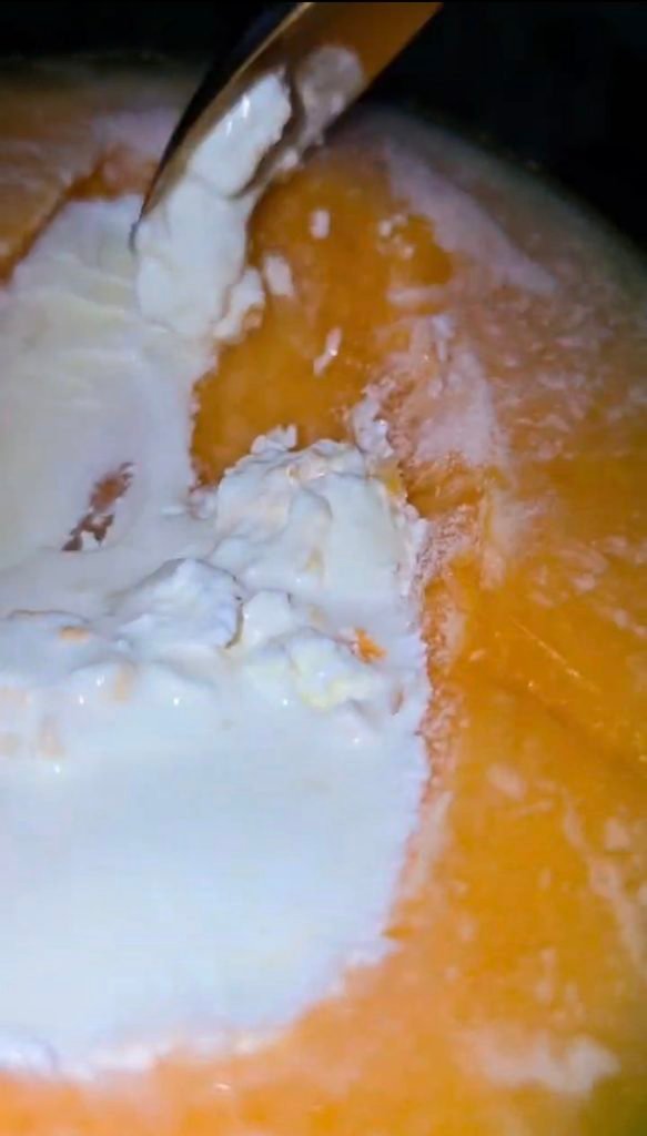 creamy cantaloupe ice cream scraped inside a frozen cantaloupe